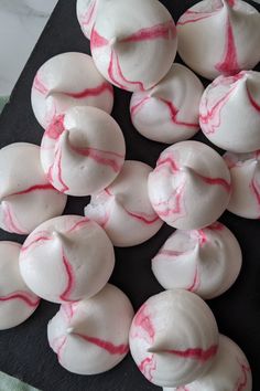 white and red swirled doughnuts on a black plate