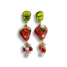 "Sicilian style earrings studs with  strawberries in Caltagirone ceramics, natural freshwater pearls and red italian coral beads. The lobe earring is made on a yellow gold plated brass base and set peridot stone, the closure is with a pin and butterfly. The ceramic element depicts \"the strawberries\". Entirely hand-painted and oven-glazed ceramic. Gold leaf decorations. Measure total length about 5 cm (Inch 2) Strawberry measures about 2cmx1.5cm (0.78 Inch x 0.59 Inch) All the materials used are hypoallergenic, nickel free as per European directives. It is an original Sicilian handmade jewel!" Red Fruit Design Drop Earrings, Caltagirone Ceramics, Italian Minimalism, Sicilian Style, Strawberry Earrings, Earrings Summer, Handmade Jewel, Peridot Stone, Coral Earrings