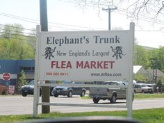 a sign that says elephant's trunk new england's largest flea market on the street