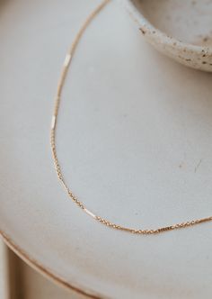 Delicate textured bars are linked together with delicate chain to add a little whimsical sparkle. Offered in 16" or 18" lengths. Available in 14kt Gold Fill + Sterling Silver. KJ styles her Mari Chain with our Lenny Chain and Tiny Freshwater Pearl Necklace. Love this chain? Check out our Mari Choker and Mari Bracelet. Handmade in Eau Claire, WI. Our jewelry is handmade so each piece will be unique and may vary slightly from what is pictured. Copper Uses, Everyday Wear Jewelry, Freshwater Pearl Jewelry, Necklace Love, Freshwater Pearl Necklace, Delicate Chain, Freshwater Pearl Necklaces, Jewelry Cleaner, Bracelet Handmade