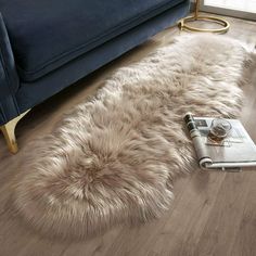 a living room with a blue couch and sheepskin rug