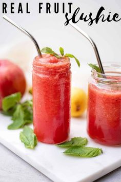 two jars with strawberries and mint sit on a white plate