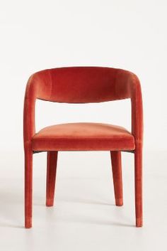 an orange chair sitting on top of a white floor