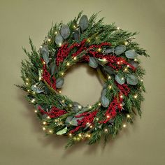 a christmas wreath with lights and greenery