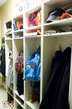 a white shelf filled with lots of backpacks