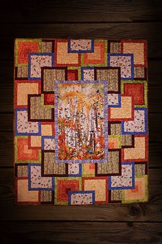 a quilted wall hanging on the side of a wooden wall