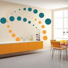 an orange and blue dining room with polka dot wall decals on the walls, along with yellow chairs