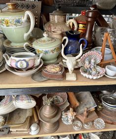 a shelf filled with lots of different types of dishes and vases on top of each other