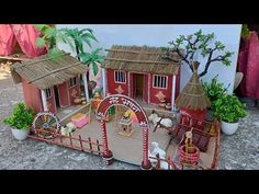 this is a model of a small village with animals and people in the front yard