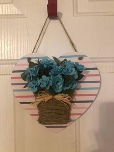 a flower pot hanging on a door hanger with twine and burlap