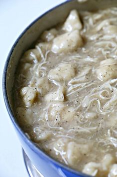 a blue pot filled with chicken and noodles