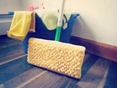 a yellow mop sitting on top of a wooden floor