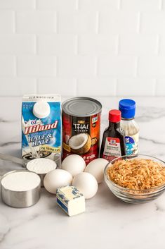 the ingredients to make this dish include eggs, cheese, and other items on a marble countertop