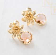 two pairs of gold earrings with pink flowers on the front and back of each ear