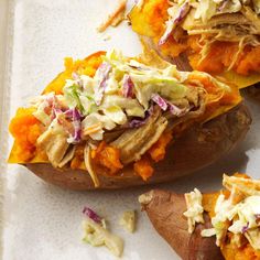 the baked potatoes have coleslaw and shredded carrots on them, along with other toppings