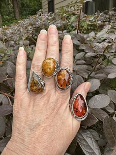 Amber rings in sterling silver.  Super nice pieces, beautiful silver work and colorful  amber on each ring.  I've got a few different sizes and these are BEING SOLD INDIVIDUALLY Athumb....size 10 B....pointer fingerSOLD...SOLD C....middle finger...8.5 D...ring finger....size 8...SOLD...SOLD... Unique Silver Baltic Amber Jewelry, Unique Amber Jewelry Stamped 925, Adjustable Amber Cabochon Rings, Handmade Oval Amber Rings, Handmade Amber Open Ring Jewelry, Amber Sterling Silver Ring With Polished Finish, Adjustable Sterling Silver Ring With Amber Color, Unique Orange Cabochon Ring, Adjustable Sterling Silver Rings In Amber