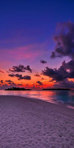 the sun is setting on an empty beach