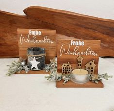 two wooden signs sitting on top of a table next to a bowl and candle holder