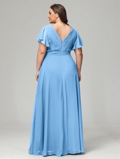 a woman in a blue dress with her back to the camera