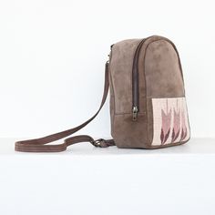 The lightweight mini backpack lets you carry your essentials in comfort and minimalist style with a low profile. Sophistication meets function in this lovely little backpack which perfectly fits your wallet, phone and even your favorite book. Traditional techniques and natural dyes are used to achieve these gorgeous hues of sand, pink and purple. Main compartment: 8" x 10" x 3" Front pocket: 7" x 4.5" Internal zippered pocket Straps: 31" - 35" Brown Standard Backpack With Mobile Phone Bag, Brown Backpack With Mobile Phone Bag, Brown Backpack With Cell Phone Pocket For On-the-go, Beige Backpack With Phone Pocket For Daily Use, Beige Crossbody Backpack For Everyday Use, Beige Travel Backpack With Mobile Phone Bag, Beige Leather Backpack With Zipper Pocket, Leather Backpack With Mobile Phone Bag For Daily Use, Beige Backpack With Cell Phone Pocket For Everyday Use