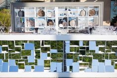 several pieces of glass are arranged on the outside of a building with grass growing in it