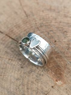 A gorgeous 5mm rose cut Jade spinner ring and a silver heart spinner both on a 1cm hammered silver band. Stamped inside with a Lotus flower that symbolises strength and feathers which are said to symbolise  trust, honor, strength, wisdom, power, and freedom  ( these stamps are optional) Made to order so please let me know a ring size. Metal Art Jewelry, Silver Wire Rings, Silversmithing Jewelry, Metalsmithing Jewelry, Silver Jewelry Design, Silver Spinner Rings, Handmade Wire Jewelry, Hippie Jewelry, Spinner Ring