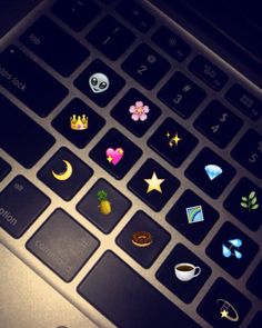 an open laptop computer with various stickers on the keyboard and mouse pad, all in different shapes and sizes