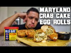 a man sitting at a table with some food in front of him and the words, maryland crab cake egg rolls