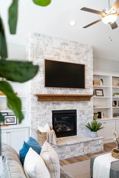 a living room filled with furniture and a flat screen tv mounted on the wall above a fireplace