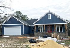 a blue house with two garages in the front yard