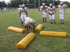 a group of football players standing on top of a field next to bouncy tubes