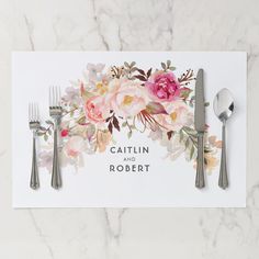 a place setting with silverware and flowers on the table, next to a card that says cattin and robert