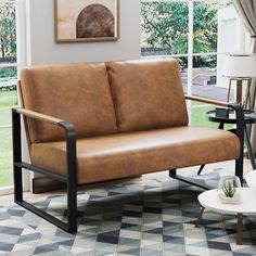 a living room with a brown leather couch and coffee table in front of a window