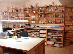 a room filled with lots of wooden shelves and desks covered in cluttered items