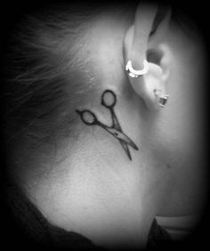 a woman's behind the ear tattoo with scissors on her left side ribcage