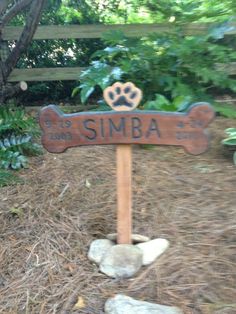 a wooden sign that says simba with a dog's paw on it