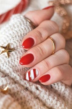 Close-up of festive winter nail idea featuring classic red polish with an accent candy cane design of white and gold stripes, perfect for the holiday season. Festive Manicure, Christmas Nails Acrylic, Design Nails, Festive Look, Manicure Ideas, Xmas Nails