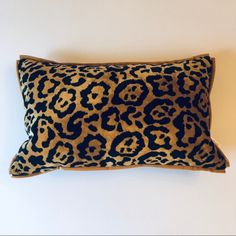 a leopard print pillow sitting on top of a white wall