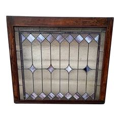 an old stained glass window with wooden frame