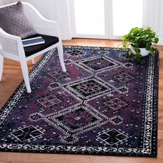 a white chair sitting on top of a wooden floor next to a black and white rug