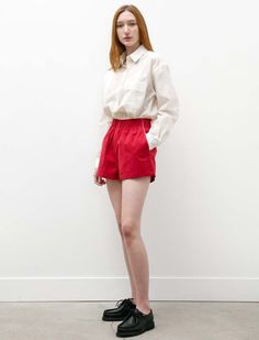 A classic camiel style has returned once more to accompany your leisure days. the shorty shorts feature crisp cotton in a washed out red to remind us of the sunny days ahead. they feature a highrise and elasticized waist band for easy wear. additional details include contrasting pipping to highlight the silhouette and offer some depth of colour.    - made in the netherlands  - 100% cotton  - machine wash cold and hang to dry  - hanna is 5’9”; bust 31.5” waist 25”; hips 35: wears a size small Casual Red Bottoms For Daywear, Casual Red Bermuda Shorts For Summer, Red Bottoms For Summer Daywear, Spring Red Cotton Shorts, Red Cotton Summer Shorts, Red Cotton Shorts For Summer, Red High-waisted Relaxed Fit Shorts, Red Cotton Shorts With Short Legs, Red Relaxed Fit Summer Bottoms