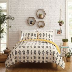 a bed in a room with white brick walls and potted plants on the wall