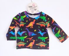 A cool classic t-shirt with long sleeves, a perfect treat for the Dinosaur lover! Made from Cotton Jersey- 95% Cotton, 5% Elastane.  Oeko-Tex standard fabrics  True to size  A perfect addition to your little ones wardrobe, why not match it with a pair of leggings? Care Instructions  -Wash at 30o -Do not tumble dry  -Cool Iron Please allow 2-3 weeks between order and dispatch as this is a handmade to order item. Neutral Autumn, Long Romper, Personalized Embroidered, Birthday Dresses, Winter Outfit, 3 Weeks, Short Tops, Long Sleeve T Shirt, Baby Toddler