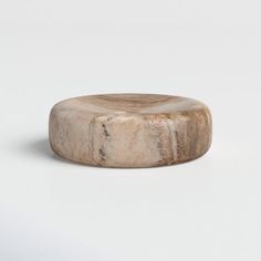 a round wooden object sitting on top of a white surface with no one around it