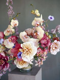 a vase filled with lots of different colored flowers