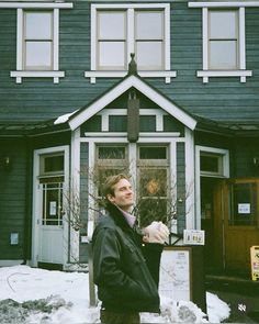 a man standing in front of a building with snow on the ground