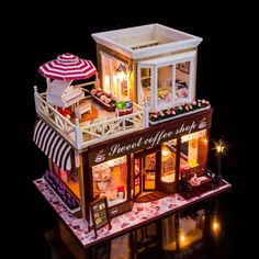 a doll house with lights and furniture on the top floor is lit up at night