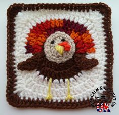 a crocheted square with a turkey on it's face in brown, white and orange colors