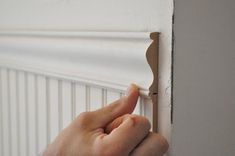 a person's hand is holding on to a door handle that is attached to the wall