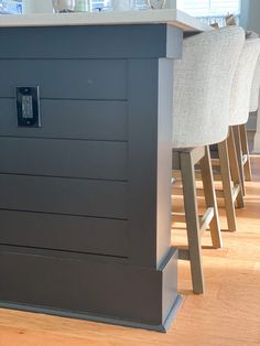 a kitchen island with stools in front of it